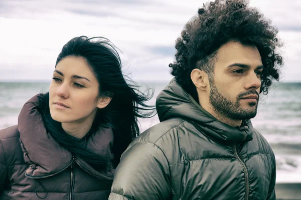 Triste pareja frente a la playa pensando —  Fotos de Stock