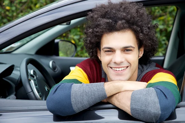 Šťastný muž v autě s úsměvem vypadající fotoaparát — Stock fotografie