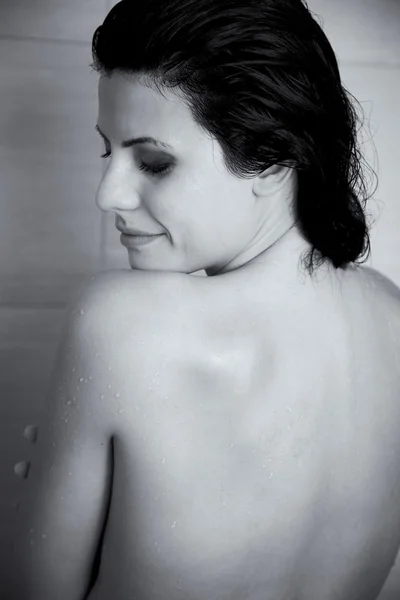 Retrato preto e branco de mulher bonita relaxando no chuveiro — Fotografia de Stock
