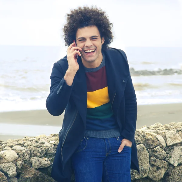 Feliz homem legal sorrindo falando no telefone em frente ao estilo retro oceano — Fotografia de Stock