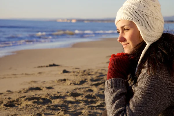 Smiling woman with hat looking ocean in winter — Stock Photo, Image