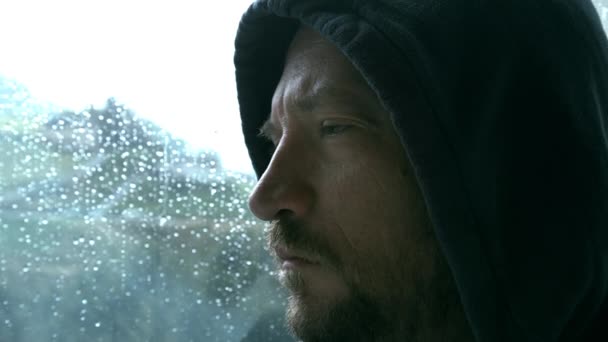 Разбушевавшийся мужчина во время дождя у окна — стоковое видео