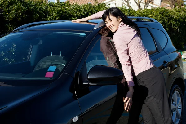 Lachende vrouw knuffelen haar nieuwe auto — Stockfoto