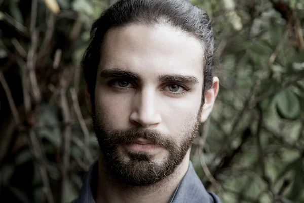 Nahaufnahme Porträt eines modernen jungen Mannes mit Bart und langen Haaren — Stockfoto