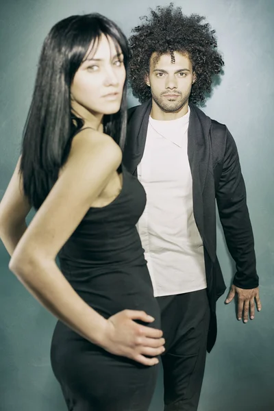 cool elegant model couple posing in studio looking at camera