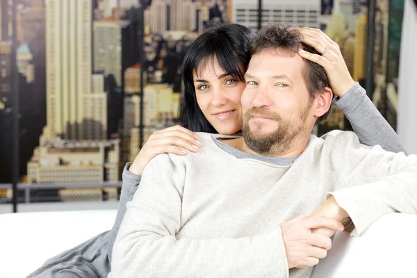 Gelukkig man en vrouw verliefd op zoek camera zittend op de Bank thuis in de stad — Stockfoto