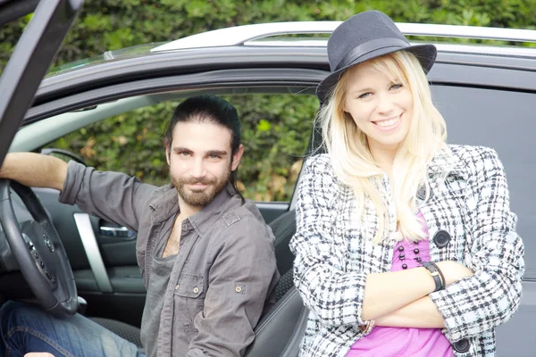 Feliz hipster pareja en frente de coche sonriendo mirando cámara —  Fotos de Stock