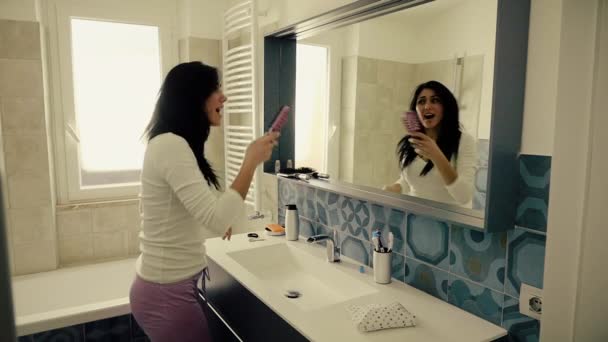 Mujer feliz bailando mientras cepilla el cabello en el baño cámara lenta — Vídeos de Stock