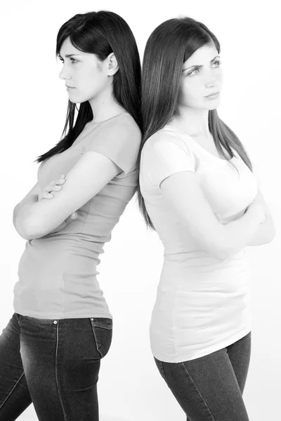 Дві сумні жінки сердиться один на одного, не розмовляючи ізольованою чорно-білою вертикаллю — стокове фото