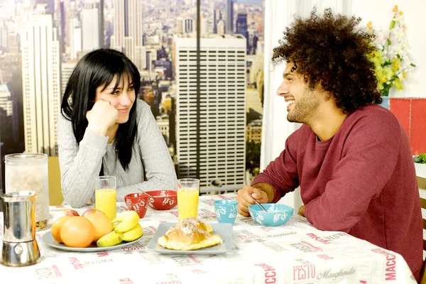 Pareja feliz desayunando frente a rascacielos en la ciudad — Foto de Stock