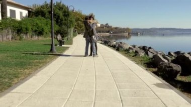 Kamera hareket ediyor. Birbirlerine aşık çiftler gölün önünde birbirlerine sarılıyorlar.