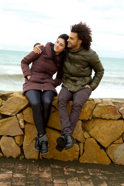 Счастливая влюбленная пара, обнимающаяся у океана зимой — стоковое фото