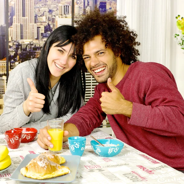 Casal feliz, tomando café da manhã na frente de arranha-céus na cidade procurando polegar câmera — Fotografia de Stock