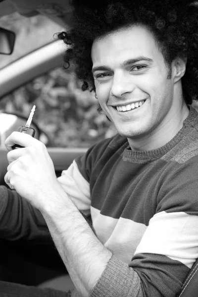 Hombre feliz en coche nuevo con llave en la mano en blanco y negro — Foto de Stock