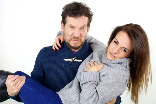 Husband making funny face while holding in arms cute redhead wife isolated — Stock Photo, Image