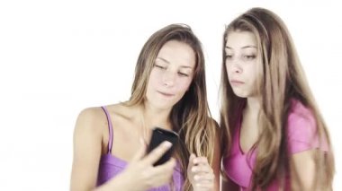 Komik kızlar cep telefonuyla fotoğraf çekerken deli suratlar yapıyor.