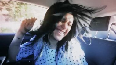 Yavaş çekim kadın arabada dans ederken eğleniyor.