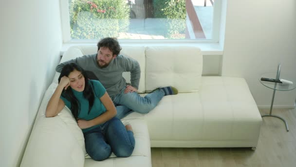 Hombre y mujer luchando en casa sentados en el sofá — Vídeos de Stock