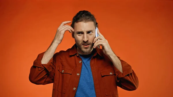 Kafası Karışmış Genç Adam Akıllı Telefonda Turuncu Ile Konuşuyor — Stok fotoğraf