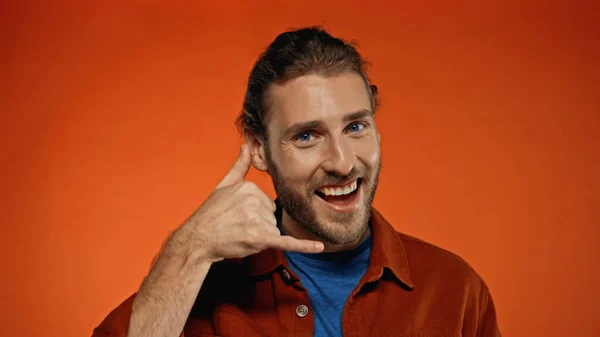 Hombre Alegre Barbudo Sonriendo Mientras Que Muestra Llámame Gesto Naranja —  Fotos de Stock