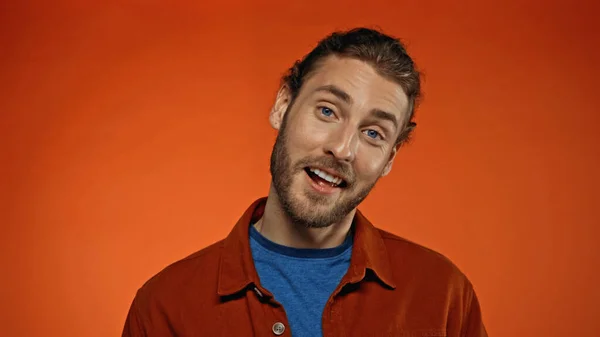 Hombre Feliz Barbudo Sonriendo Mientras Mira Cámara Naranja — Foto de Stock