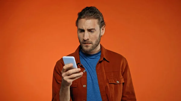 Сфокусированный Бородатый Мужчина Помощью Мобильного Телефона Оранжевом Фоне — стоковое фото