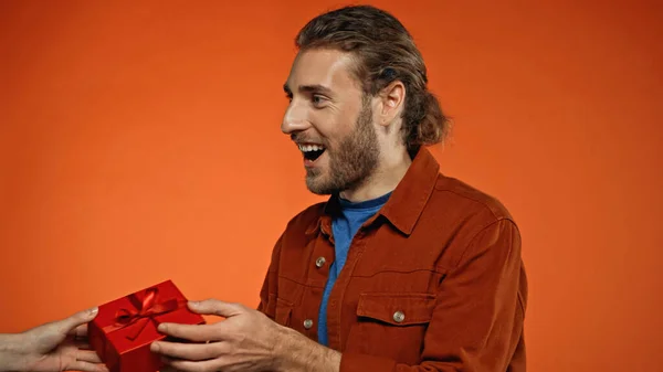 Happy Young Man Receiving Wrapped Present Orange — Stock Photo, Image