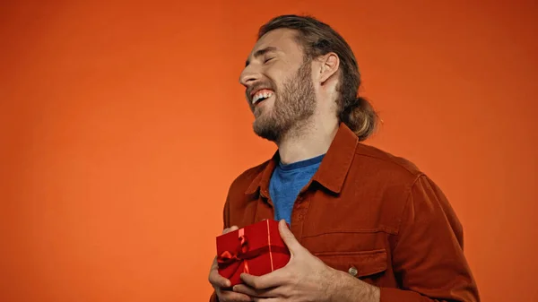 Happy Young Man Closed Eyes Holding Wrapped Present Orange — Stock Photo, Image