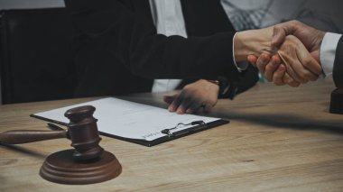 Sigorta acentelerinin evrak ve tokmağın yanında el sıkışırken çekilmiş görüntüsü 