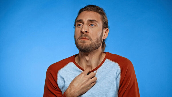 бородатый молодой человек чувствует неприятный запах на голубом