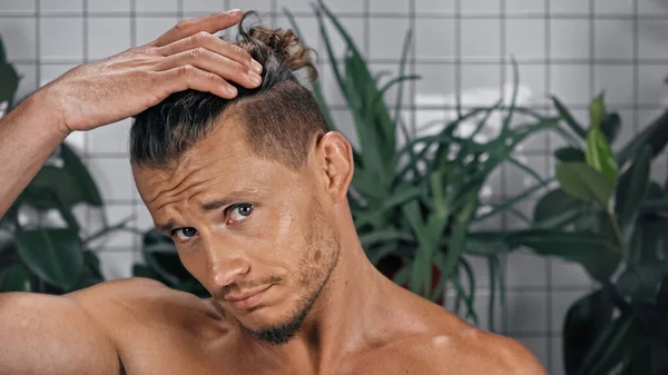 Hombre Joven Sin Camisa Mirando Cámara Ajustando Cabello Cerca Las — Foto de Stock