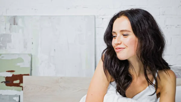 Genç Esmer Kadın Yatak Odasında Otururken Gülümsüyor — Stok fotoğraf