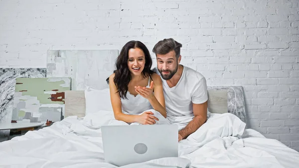 Excited Woman Pointing Hand Laptop While Watching Movie Boyfriend Bed — Stock Photo, Image