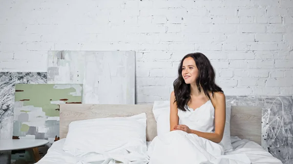 Alegre Morena Mujer Sonriendo Mientras Sienta Cama Por Mañana — Foto de Stock