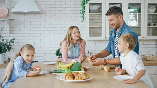 Vater Hält Baguette Neben Essen Und Familie Küche — Stockfoto