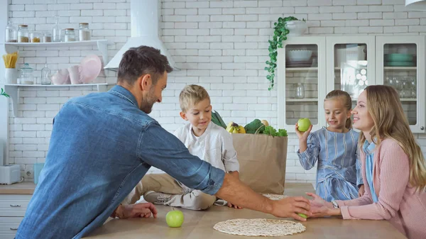 Lächelnde Familie Mit Kindern Steht Neben Papiertüte Mit Lebensmitteln Hause — Stockfoto