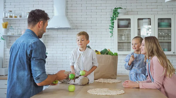 Smiling Parents Kids Standing Apples Food Paper Bag Kitchen — Stock Photo, Image