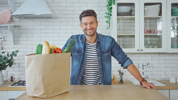 Sonriente Hombre Mirando Cámara Cerca Alimentos Frescos Cocina —  Fotos de Stock
