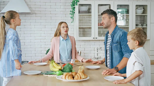 Familie Mit Kindern Plaudert Neben Essen Und Tellern Auf Küchentisch — Stockfoto