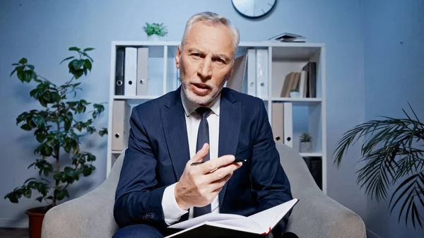 Geschäftsmann Mit Notizbuch Spricht Während Videotelefonie Büro — Stockfoto