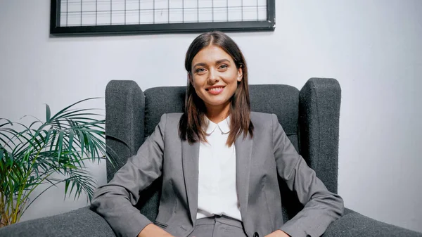 Młoda Bizneswoman Uśmiechnięta Siedząc Fotelu Biurze — Zdjęcie stockowe