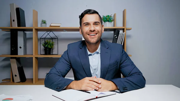 Hombre Negocios Sonriente Mirando Cámara Cerca Del Cuaderno Papeles Primer —  Fotos de Stock