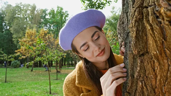 Feliz Jovem Mulher Sorrindo Tocar Tronco Árvore Parque — Fotografia de Stock