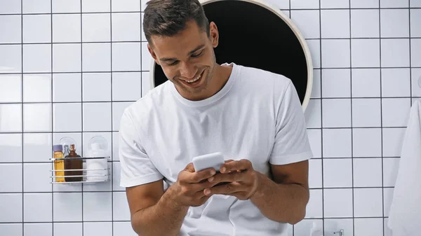 Smiling Man White Shirt Chatting Smartphone Bathroom — Stock Photo, Image