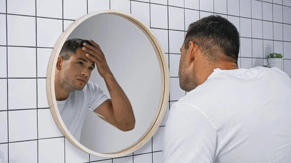 Joven Tocando Frente Mientras Mira Espejo Baño —  Fotos de Stock