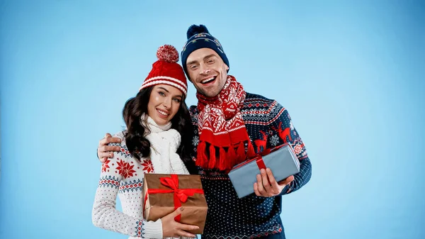 Smiling Couple Warm Sweaters Holding Gift Boxes Blue Background — Stock Photo, Image