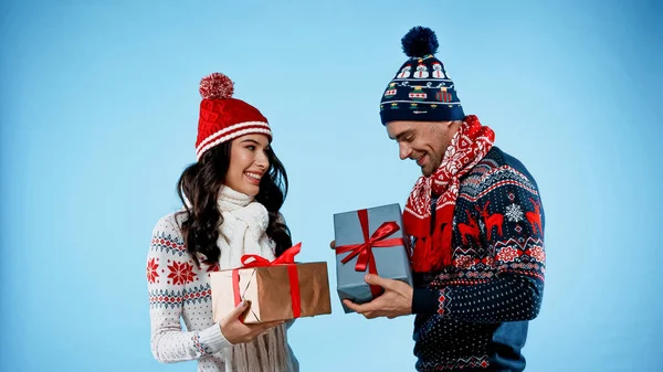 Cheerful Young Couple Hats Sweaters Holding Presents Blue Background — Stock Photo, Image