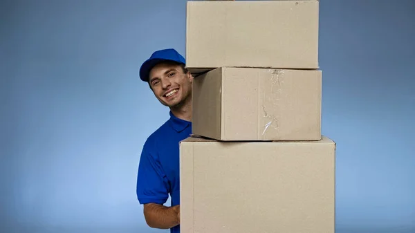 Cheerful Delivery Man Holding Carton Boxes While Smiling Camera Isolated — Stock Photo, Image