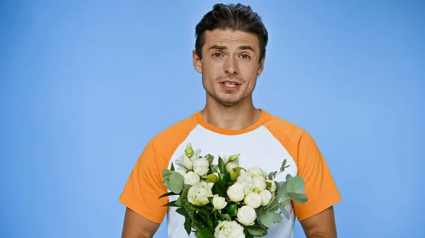 Confused Man Holding Fresh Bouquet Isolated Blue — Stock Photo, Image