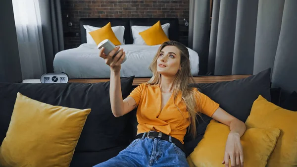 Tattooed Woman Holding Remote Controller While Suffering Heat Hotel Room — Stock Photo, Image